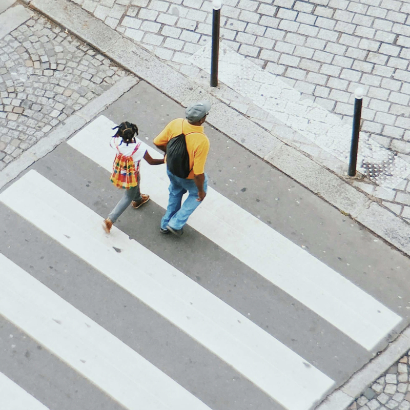 A father and daughter cross the road