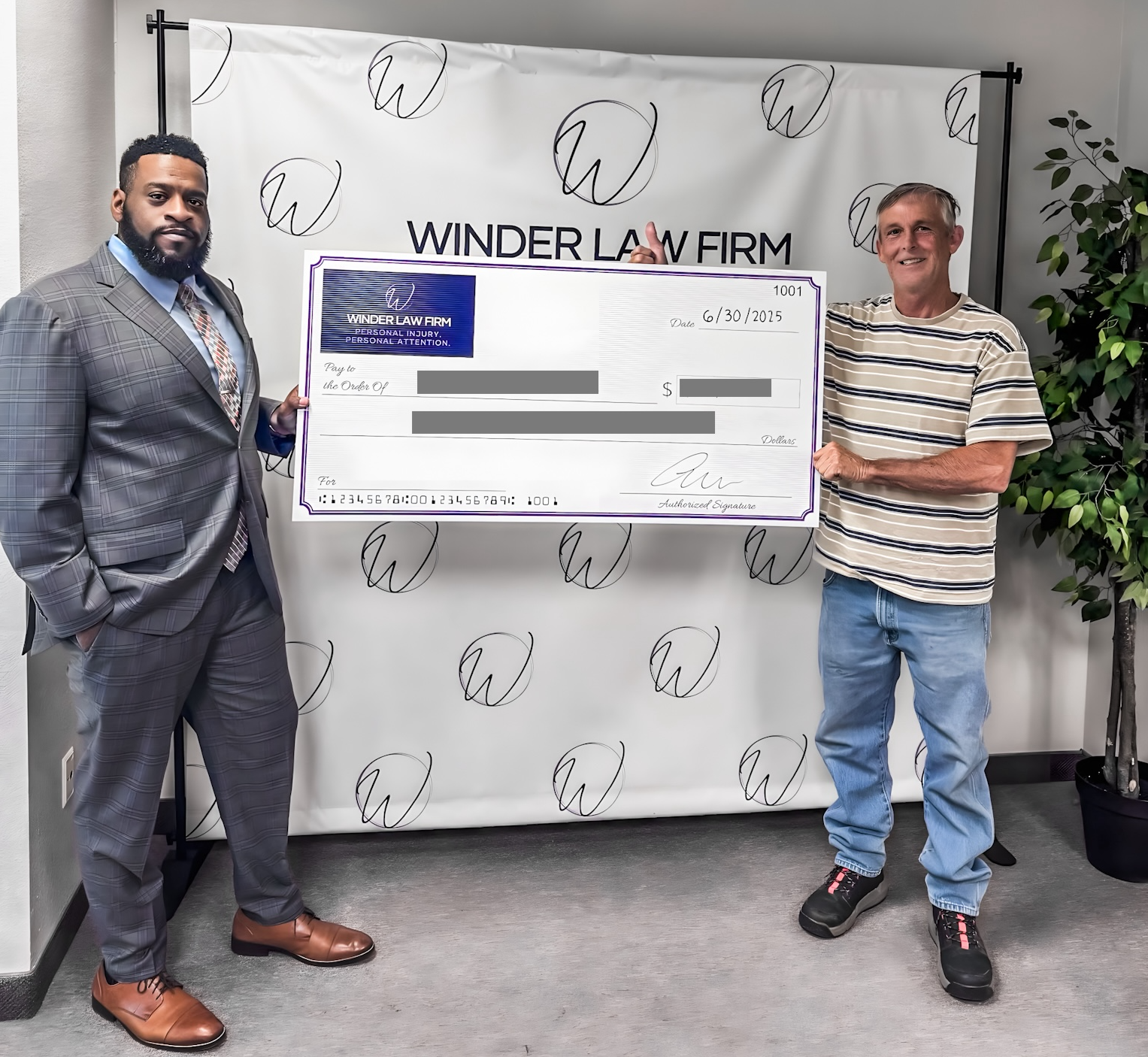 Aaron A. Winder presenting a settlement check to Joe Lewis.